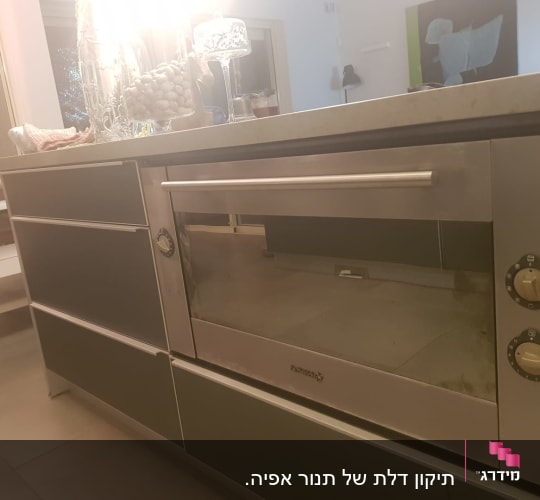 תנור אפור עם כפתורים עגולים במטבח מודרני